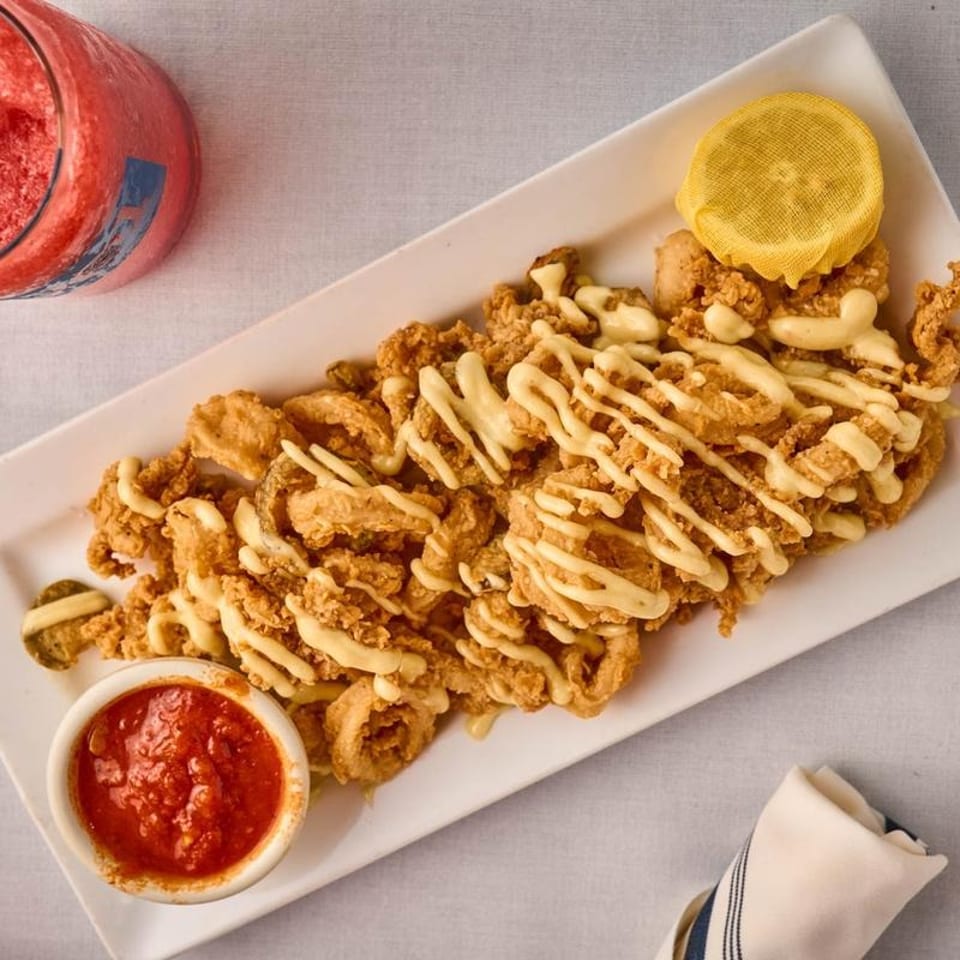 Crispy fried calamari drizzled with aioli, served with marinara sauce and a lemon wedge.